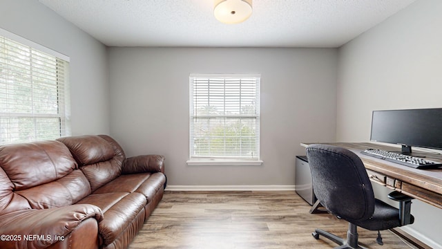 office area with a textured ceiling and light hardwood / wood-style floors