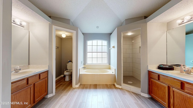 full bathroom with a textured ceiling, toilet, vaulted ceiling, vanity, and shower with separate bathtub