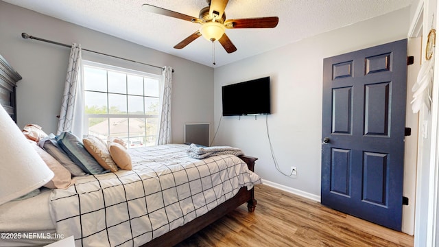 bedroom featuring ceiling fan, a textured ceiling, and hardwood / wood-style flooring