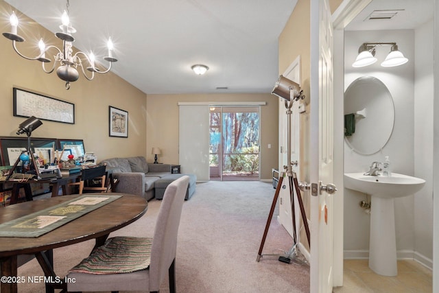 dining area with light colored carpet, sink, and an inviting chandelier