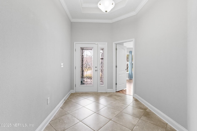 tiled entryway featuring a raised ceiling and ornamental molding