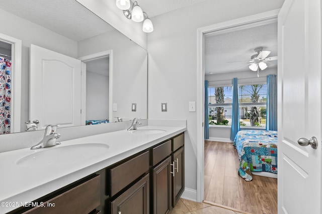 bathroom featuring vanity, a textured ceiling, and ceiling fan