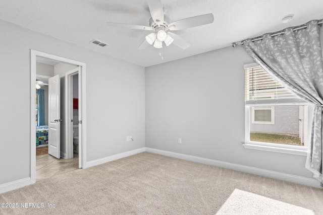 unfurnished bedroom featuring multiple windows, ceiling fan, and light carpet