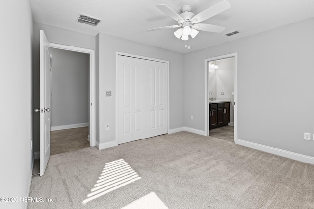 unfurnished bedroom featuring ceiling fan, a closet, and light colored carpet