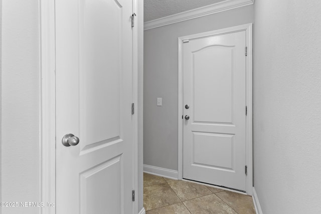 entryway featuring crown molding, light tile patterned floors, and a textured ceiling