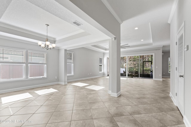 interior space featuring ceiling fan with notable chandelier, a raised ceiling, light tile patterned floors, and crown molding