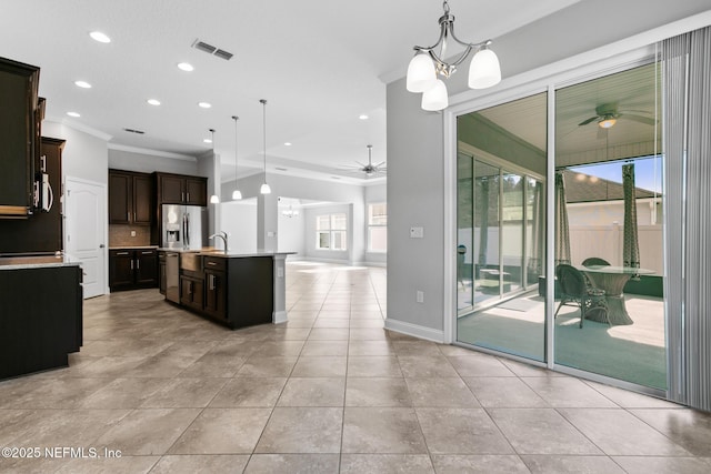 kitchen with dark brown cabinets, stainless steel appliances, sink, pendant lighting, and an island with sink