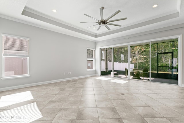 spare room with light tile patterned floors, a raised ceiling, ceiling fan, and ornamental molding