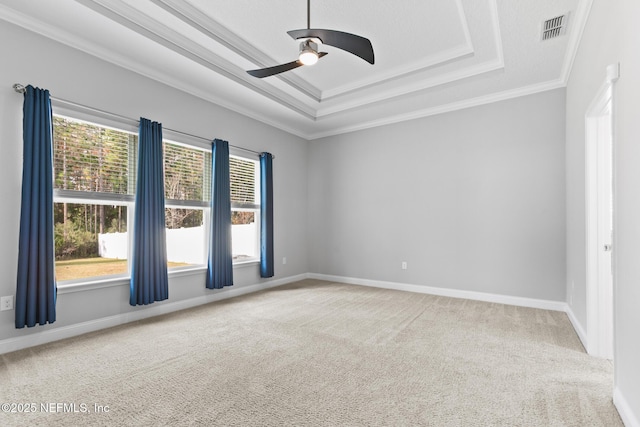 carpeted empty room featuring a raised ceiling, ceiling fan, and ornamental molding