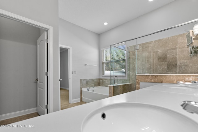 bathroom with tile patterned floors, sink, and plus walk in shower