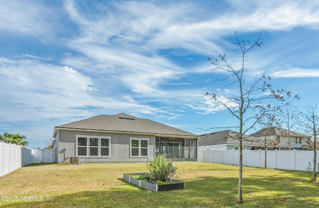 rear view of property with a sunroom and a yard