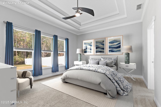 bedroom with carpet floors, a raised ceiling, ceiling fan, and crown molding