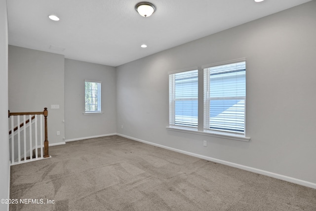 empty room featuring plenty of natural light and light colored carpet