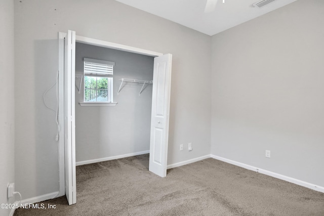 unfurnished bedroom featuring carpet, ceiling fan, and a closet