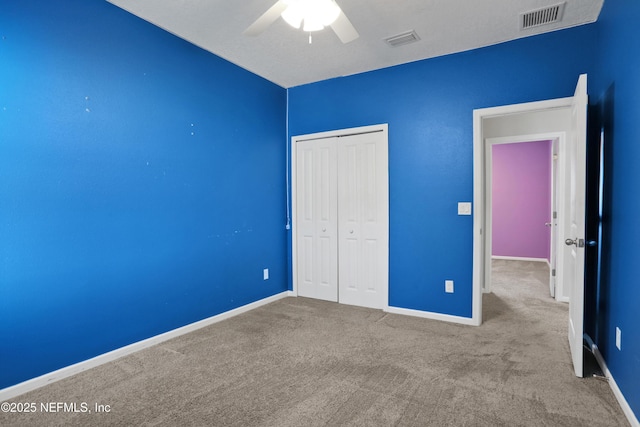 unfurnished bedroom with carpet, ceiling fan, and a closet