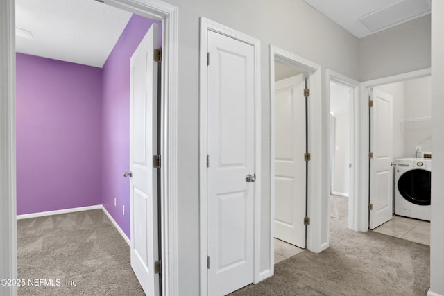 corridor featuring washer / clothes dryer and light colored carpet