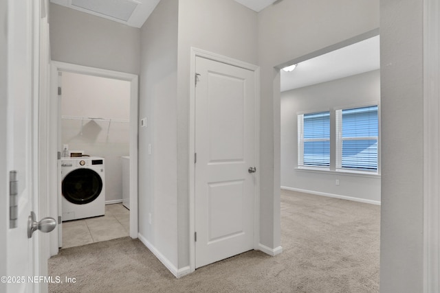 corridor with light carpet and washer / clothes dryer