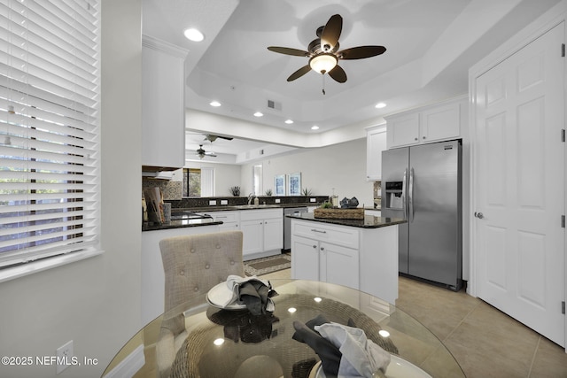 kitchen featuring kitchen peninsula, appliances with stainless steel finishes, a tray ceiling, and white cabinets