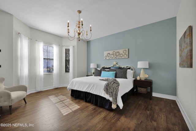 bedroom with an inviting chandelier and dark hardwood / wood-style floors