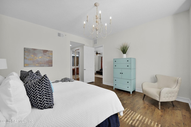 bedroom with a notable chandelier and dark hardwood / wood-style floors