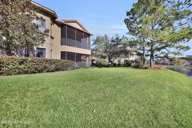 view of yard featuring a water view and a sunroom