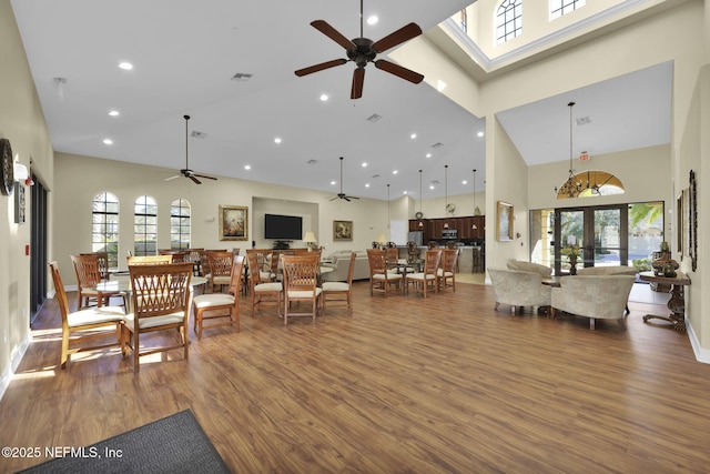 living room with ceiling fan, dark wood-type flooring, french doors, and a towering ceiling