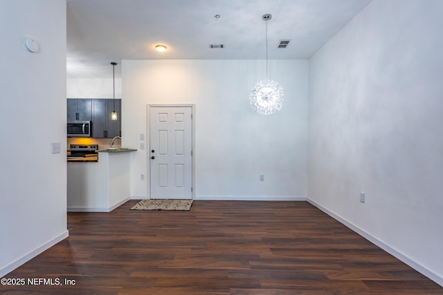 interior space with a notable chandelier, dark wood-type flooring, and sink