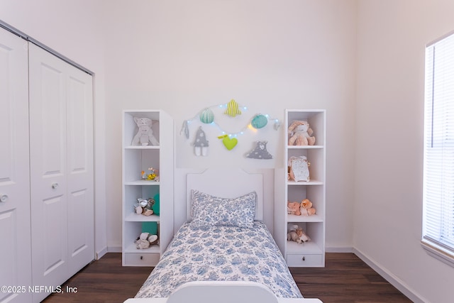 bedroom with dark hardwood / wood-style floors and a closet