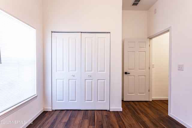 unfurnished bedroom with a closet and dark hardwood / wood-style floors