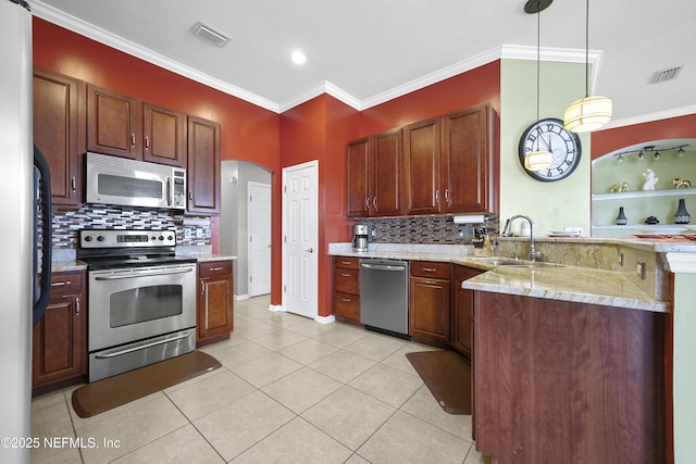 kitchen with visible vents, arched walkways, hanging light fixtures, stainless steel appliances, and a sink