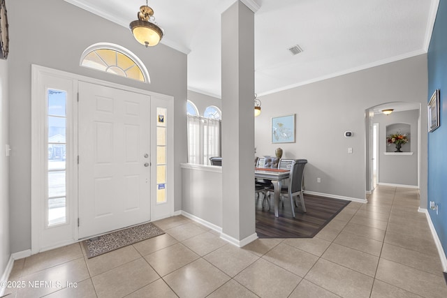 entryway with light tile patterned floors, ornamental molding, plenty of natural light, and visible vents