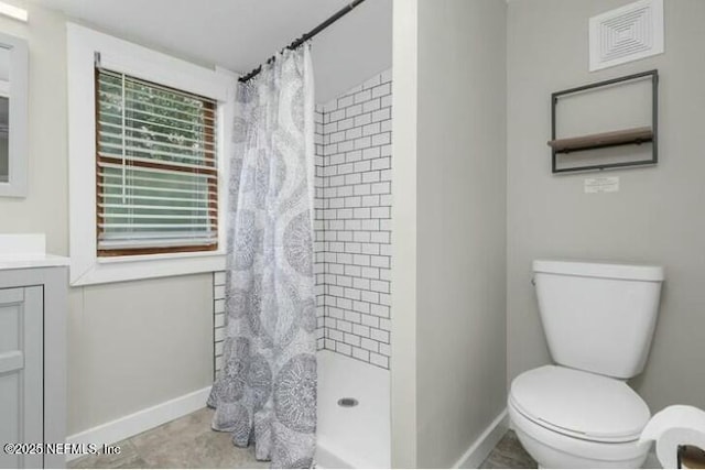 bathroom featuring tile patterned flooring, vanity, toilet, and walk in shower