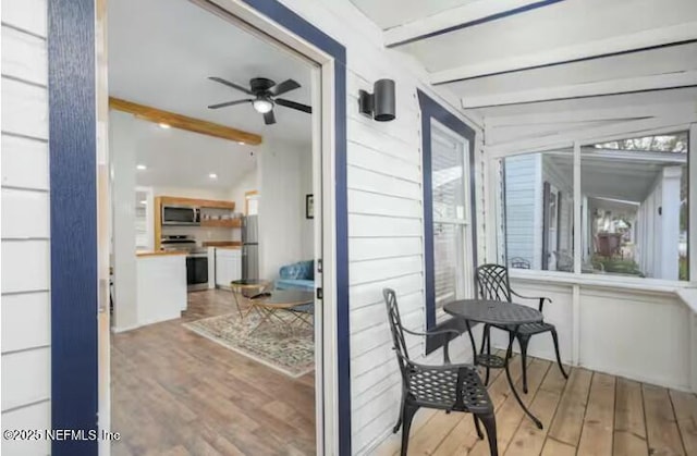 sunroom featuring ceiling fan and beam ceiling