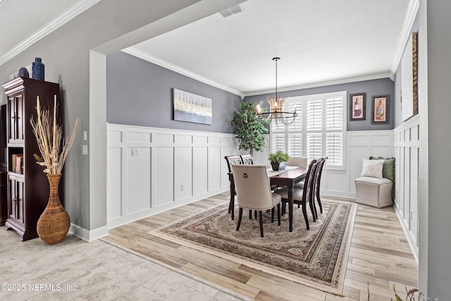 dining area featuring ornamental molding, a textured ceiling, and a chandelier