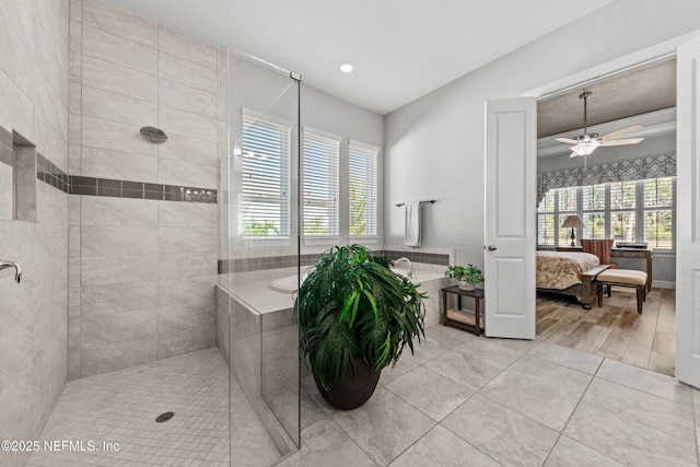 bathroom featuring tiled shower, tile patterned flooring, plenty of natural light, and ceiling fan