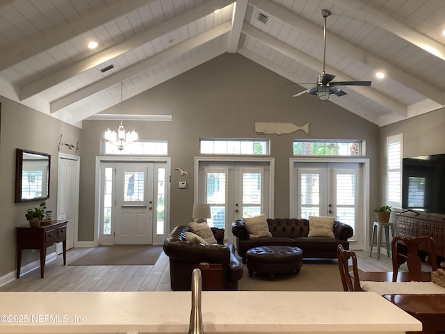 living room featuring ceiling fan with notable chandelier, a towering ceiling, and french doors