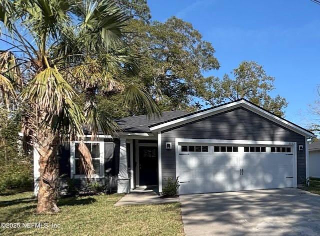 view of front of property with a front yard and a garage