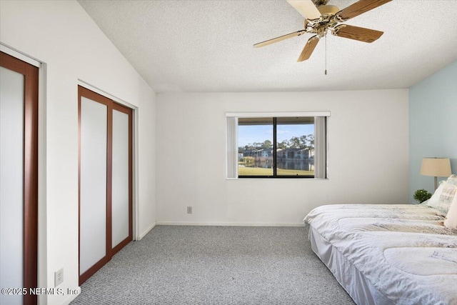 carpeted bedroom with ceiling fan and a textured ceiling