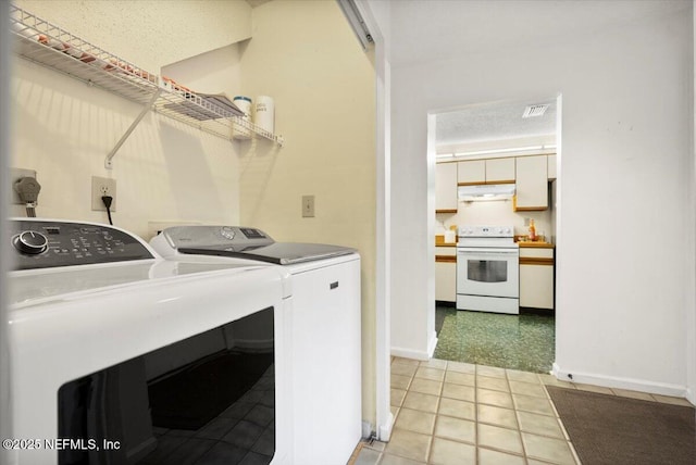 laundry area with washing machine and dryer and a textured ceiling