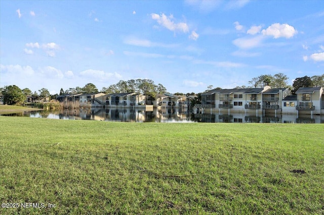 view of home's community with a water view and a yard