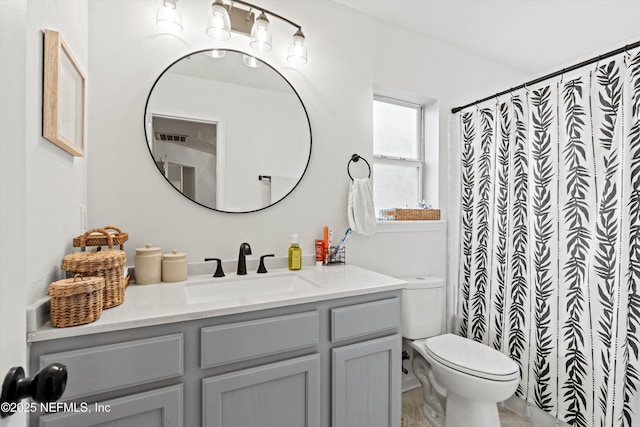 bathroom featuring a shower with shower curtain, vanity, and toilet