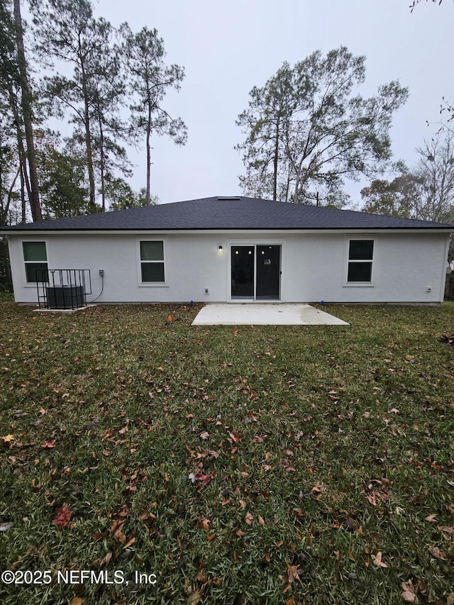 back of property with a lawn and a patio area