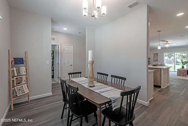 dining room with ceiling fan with notable chandelier and dark wood-type flooring