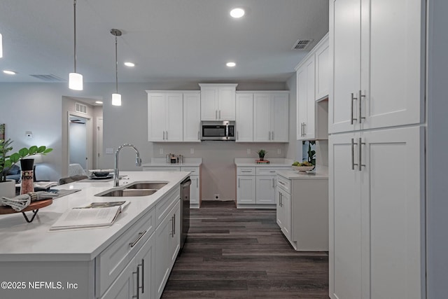 kitchen featuring decorative light fixtures, white cabinetry, sink, and appliances with stainless steel finishes