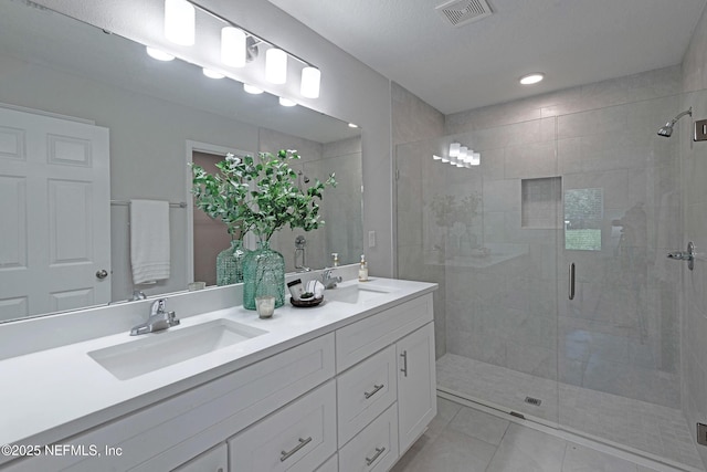 bathroom featuring tile patterned flooring, vanity, and a shower with door