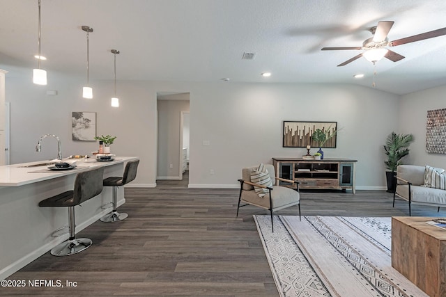 living room with sink, vaulted ceiling, dark hardwood / wood-style floors, ceiling fan, and a textured ceiling