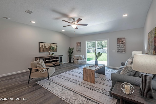 living room with a textured ceiling, dark hardwood / wood-style flooring, ceiling fan, and lofted ceiling