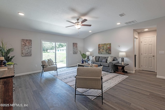 living room with ceiling fan, dark hardwood / wood-style flooring, lofted ceiling, and a textured ceiling