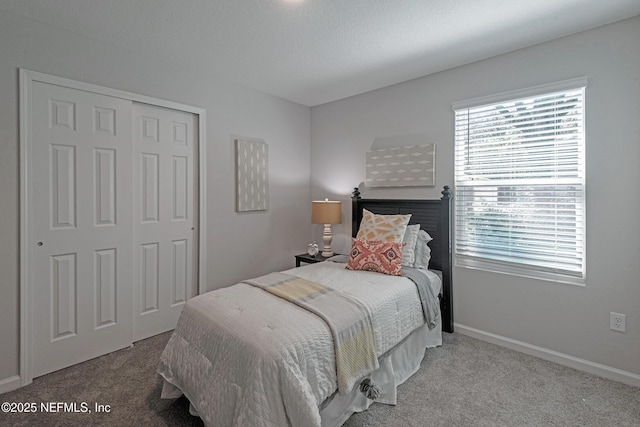 bedroom with a textured ceiling, light carpet, and a closet