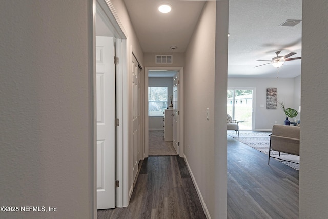 corridor featuring dark hardwood / wood-style flooring and a textured ceiling